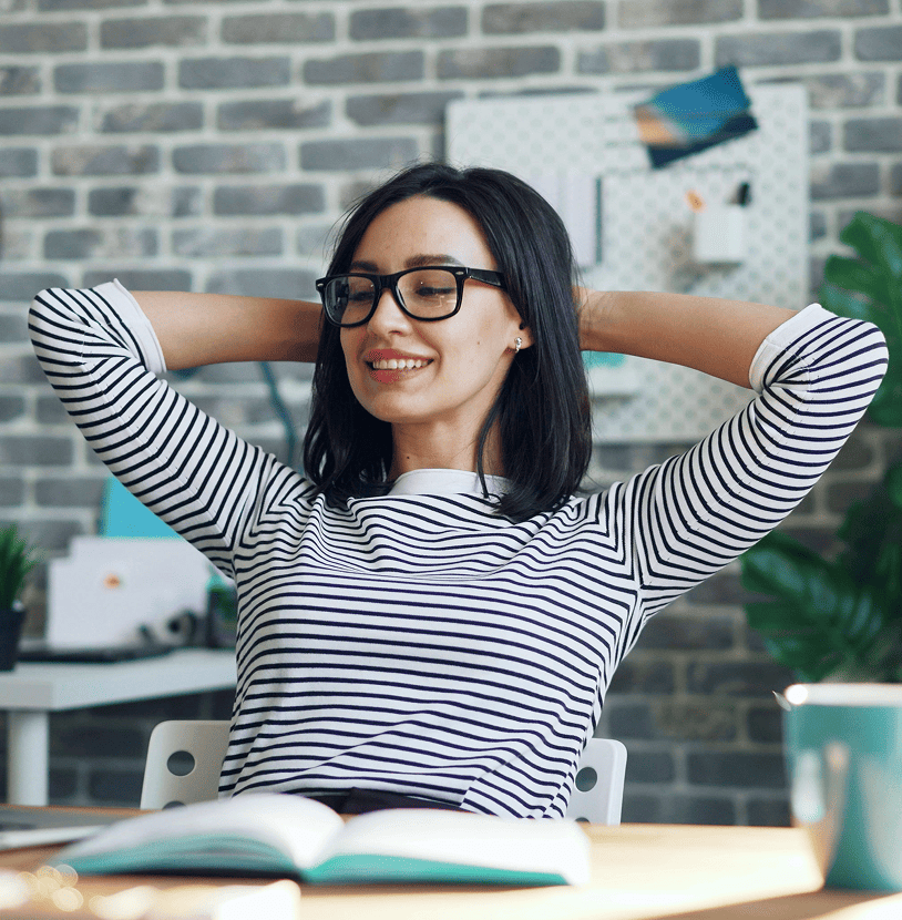 A business owner leaning back at her desk, relaxed