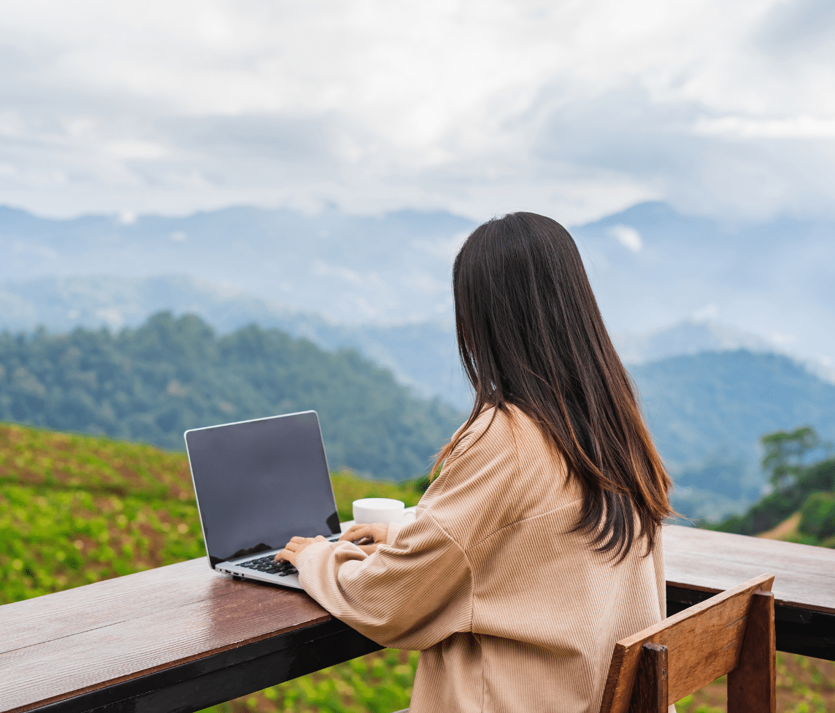 A freelancer working on a laptop at an outdoor table