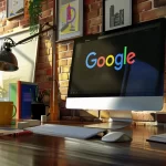 A desktop with an iMac, showing the Google logo