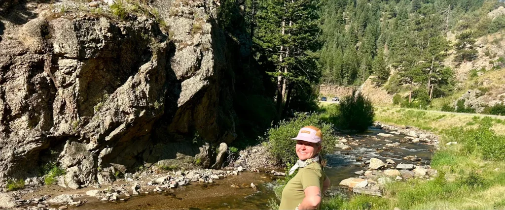 michelle larson near a stream while hiking in colorado